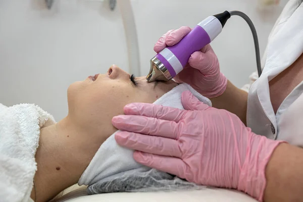 cosmetologist make rejuvenation procedure on face with hardware, ultrasound procedure. Beauty treatment