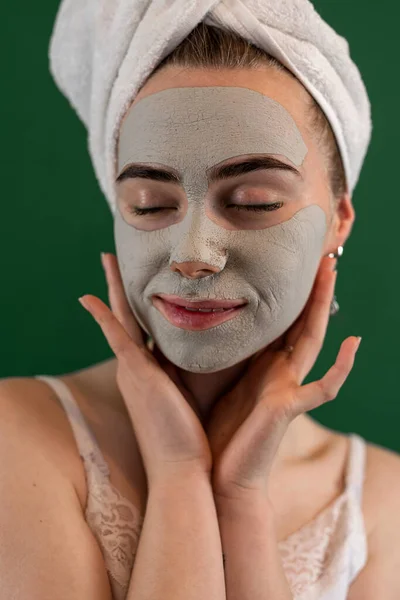 Junge Frau Die Grüne Tonmaske Isoliert Auf Grün Aufträgt Schönheitsbehandlungen — Stockfoto
