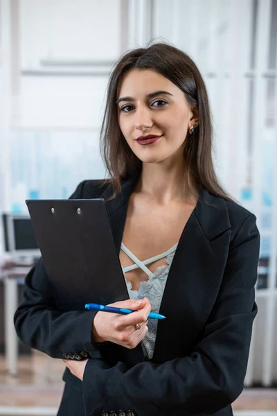 stock image Single beautiful business woman in black suit holding paper doc standing in modern office. Successful female manager