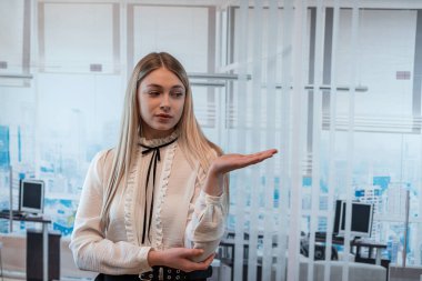 Ofiste duran bayan patron, ellerinin yardımıyla gelecekteki iş planlarını duygusal olarak açıklıyor.