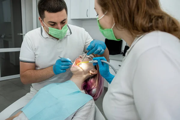 stock image male dentist and a female assistant treat a patient. concept of dentistry