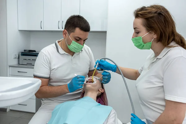 Dentysta Asystentka Operują Młodą Uśmiechniętą Kobietę Klinice Dentystycznej Koncepcja Opieki — Zdjęcie stockowe