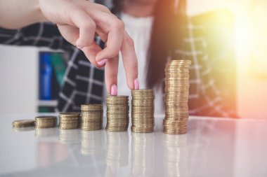  Bozuk para yığınının üzerinde yürüyen kadın parmaklarını kapat. Finansal kar büyümesi kavramı.
