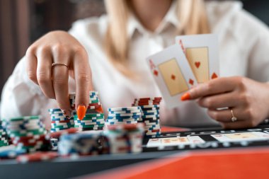 Kumarhanede poker oynayan genç ve güzel bir kadın, her şeyine bahse gir. Kumarhanede kazan. Gece oyunu, yaşam tarzı