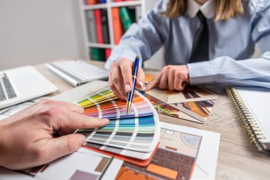 Yaratıcı kadın tasarımcı gelecek onarımlar için renk seçiyor ve mavi baskı planını çiziyor. Bir mimari yenileme konsepti