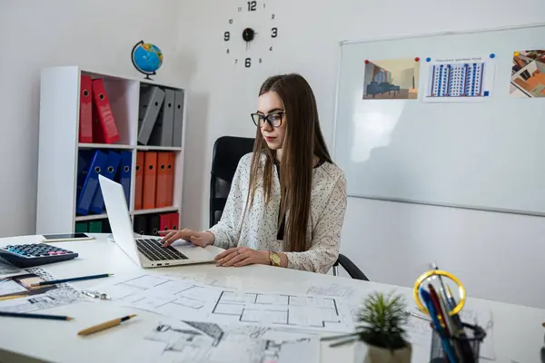 stock image Caucasian young female architect working with home drawing plan on blue print with architect equipment in the office