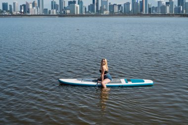 Genç kadınlar doğa için zaman harcarlar bir SUP sörf tahtası şehir gölünde, yaz tatili gezisi için