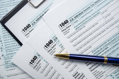 cloeup of 1040 US federal income tax return form with pen. Tax for time