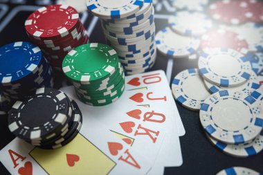 Beş poker kartında Royal Floş kombinasyonu ve kumarhane masasında cipsler. Kumar, blackjack kartları. 