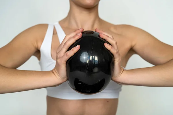 sporty girl doing exercises with a fitness ball in the gym isolated on a white wall. sporty woman doing exercises with a ball in her hands. sport.