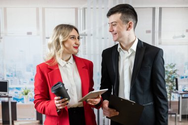 İki iş arkadaşı ofiste çalışıyor ve proje planlama stratejisi şirketi için tablet bilgisayar kullanıyorlar. Takım çalışması.
