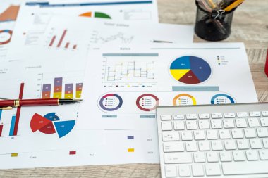 Ofis masasında bir sürü çizelge ve grafik var. Evrak işleri, veri toplama, muhasebe kavramı