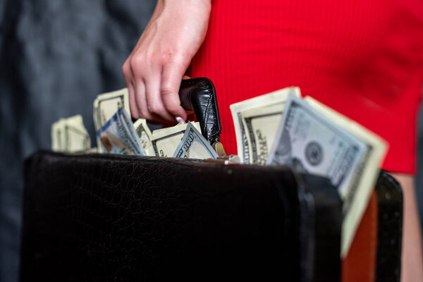 Closeup of female holding briefcase with money as bribery. Corruption illegal concept 