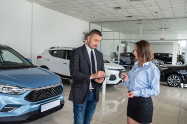 Araba galerisinde genç bir bayan müşteriyle konuşmak, galeride araba satmak ya da kiralamak.