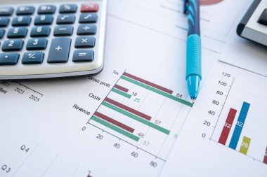 Ofis masasında kalem ve hesap makinesiyle iş dengesi raporu. Birçok grafik ve grafik