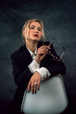 Yeni stüdyoda poz veren genç ve mutlu iş kadını. Karanlık arka planda izole edilmiş. Bir kadın portresi.