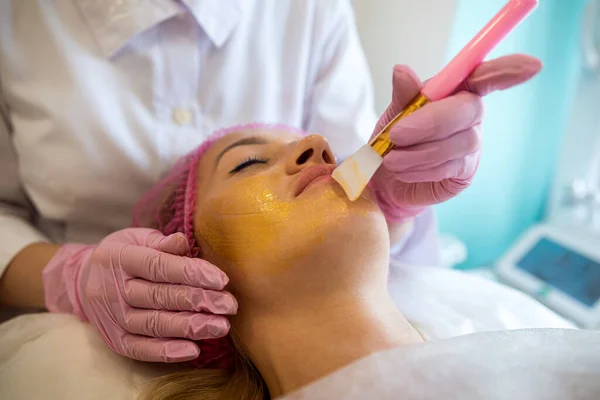 一个年轻的女孩在一个医疗温泉疗养院里来为身体剥皮和粉刺的化妆品治疗 美容院美容术程序的概念 — 图库照片