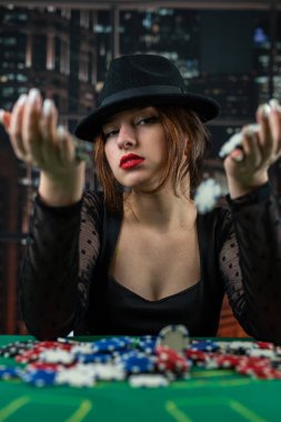 Kadın eli poker masasındaki bir kazıktan poker fişi alıyor. Pokerde riskli bahisler. Kumarhanedeki kadın.