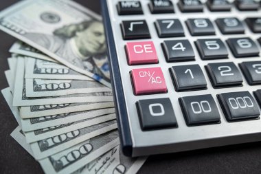 Para dolarları ve hesap makinesi siyah arka planda izole edilmiş. Ekonomi konsepti. Para dağıtımı Euro. Dolar bazen düşer ve yükselir..