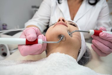 Genç ve güzel bir kadın spa kliniğinde mikroakım tedavisi görüyor. Kırışıklıkların düzeltilmesi için prosedür 