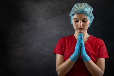 Üniformalı kadın doktor gözlerini kapadı, ellerini sıktı ve Tanrı 'ya dua etti. İnanç ve umut kavramı