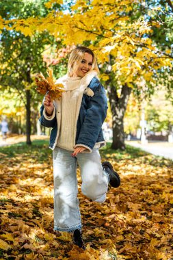 Yalnız kadın sonbahar parkında tek başına yürüyor, yaşam tarzı. Güzel sonbahar doğası