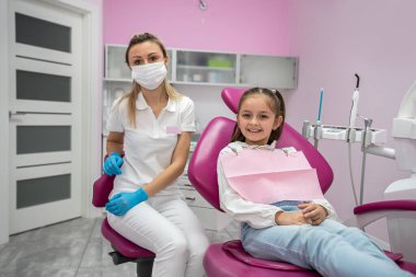 Küçük bir kız hasta muayene için dişçi kliniğine geldi. Çocuk dişçiliği konsepti. çocuk dişlerinin tedavisi