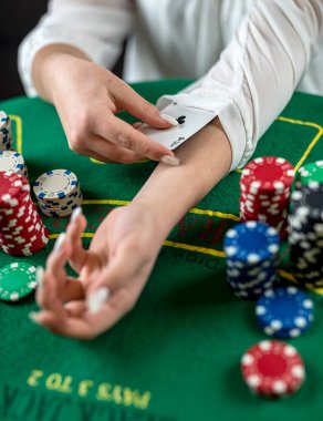 Güzel, genç bir kız poker masasında otururken çekilmiş bir fotoğraf. Poker kumarı. poker. Para için oyun