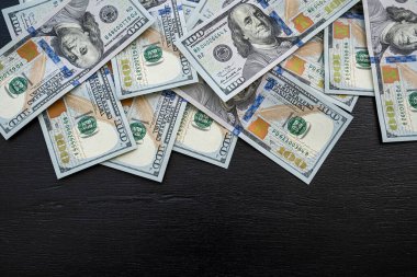 Siyah arka planda 100 yeni Amerikan doları. Gelir geliri. Kaydetme kavramı