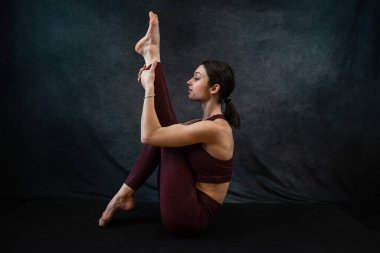 Spor giysilerinde kadın yoga eğitmeni ev stüdyosunda spor egzersizleri yapıyor. Sağlıklı yaşam tarzı kavramı