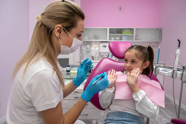Küçük kız diş ağrısı şikayetiyle dişçiye geldi. Çocuk dişçiliğinde resepsiyon. diş tedavisi