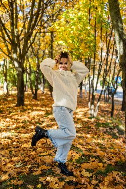 Gülümseyen genç kadın portresi Sonbahar parkında ya da ormanda yürüyor, yaşam tarzında.