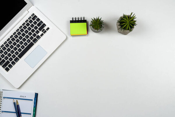  laptop computer empty notepad and pen on white office desk background, flat lay