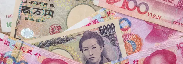 Asian money - Chinese yuan with Japanese yen bill, finance background