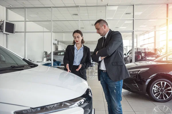 Car dealership manager help choosing car of dream for a deal to a female client in showrrom