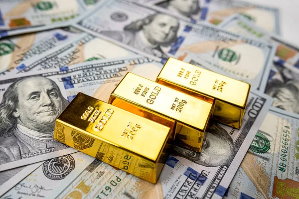 Paper us money with gold bars, saving and investment wealth. Finance themed photograph.