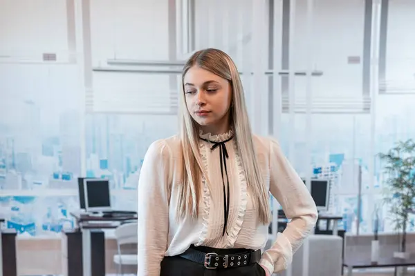 Beautiful blonde business woman in a white blouse in office building. Fashion portrait, lifestyle