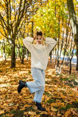 Yalnız kadın sonbahar parkında tek başına yürüyor, yaşam tarzı. Güzel sonbahar doğası