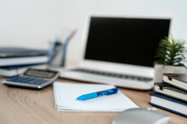 Ahşap ofis masasında bir kalem dizüstü bilgisayar. Ev konseptinde serbest çalışma
