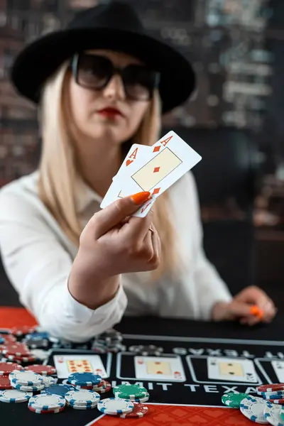 Portrait of gambling lucky woman playing poker with card and chips at casino. Gambling concept, lifestyle