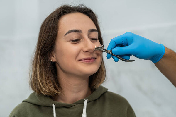 Portrait of an otolaryngologist while working with a girl patient with nasal problems. medicine. examination of the nasal sinuses