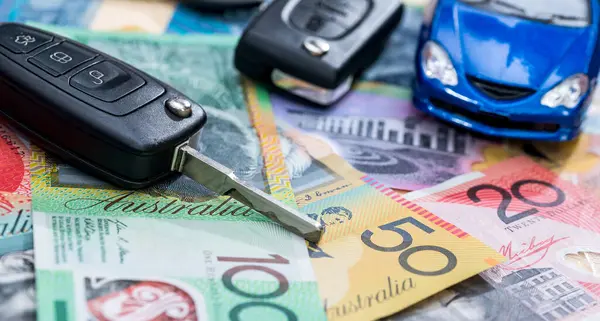 Small blue  toy car with key on aud australian dollar bills, rent or sell vehicle concept