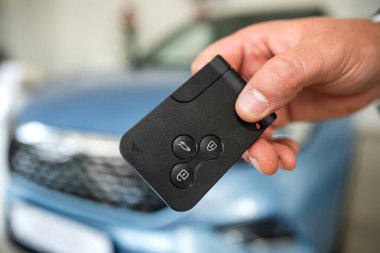 Galeride yeni bir otomobilin anahtarını tutan torbacıya yakın durun. başarı anlaşması