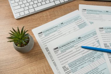 Ofis masasında kalem ve bilgisayar klavyesi olan 1040 vergi formu. Hiç kimse, kağıt işleri muhasebe kavramı.