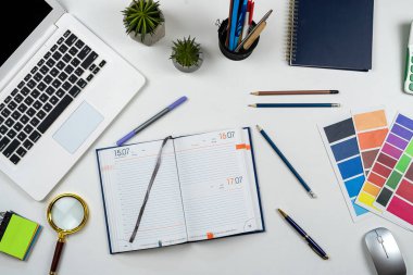 Not defterinde dizüstü kalemle ofis çalışma masasının en üst görüntüsü. Crative iş