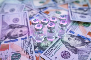 Coronavirus aşısı ya da şişedeki diğer maddeler dolar kağıtları üzerinde, aşı kavramı ve Coronavirus 'a karşı tedavi, eczane çok pahalıdır. 