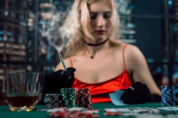 rich woman wear evening red dress playing poker, holding cigar. Poker game