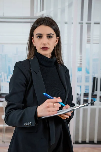 stock image Single happy businesswoman in black suit hold paper documents at office. Successful businesswoman concept