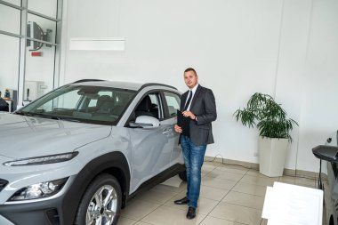 Yeni araba galerisinde, satışta ya da kira konseptinde tek başına gülen bir satıcı ya da müşteri. otomobil