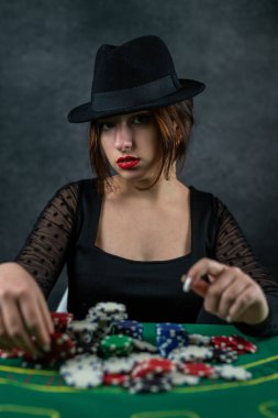 Kumarhanedeki poker masasında poker kartları ve fişleri olan seksi bir kadın. En büyük kumar oyunu. poker.